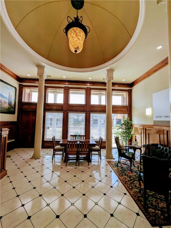 foyer featuring a raised ceiling and ornate columns