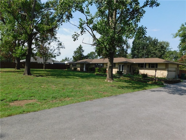 single story home featuring a garage and a front yard