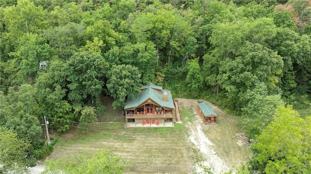 birds eye view of property featuring a forest view