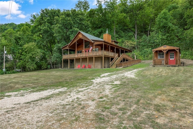 exterior space with an outbuilding, a deck, and a lawn