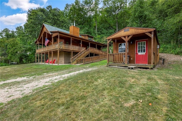view of play area with an outdoor structure, a lawn, stairs, and a deck