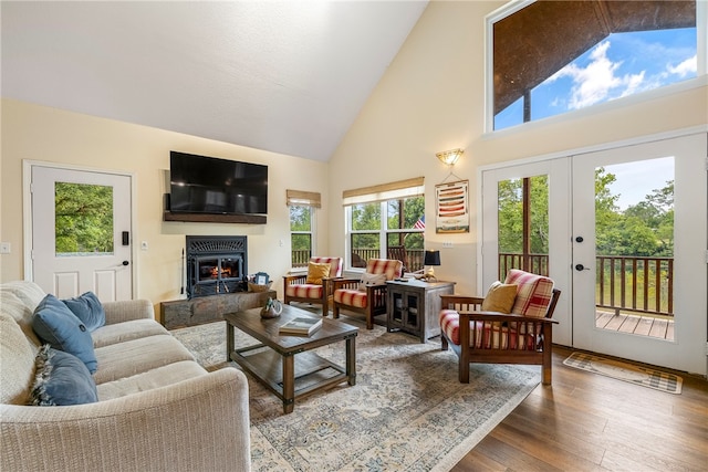 living room with hardwood / wood-style floors, high vaulted ceiling, and french doors