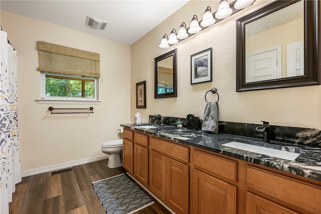 bathroom with hardwood / wood-style flooring, vanity, and toilet