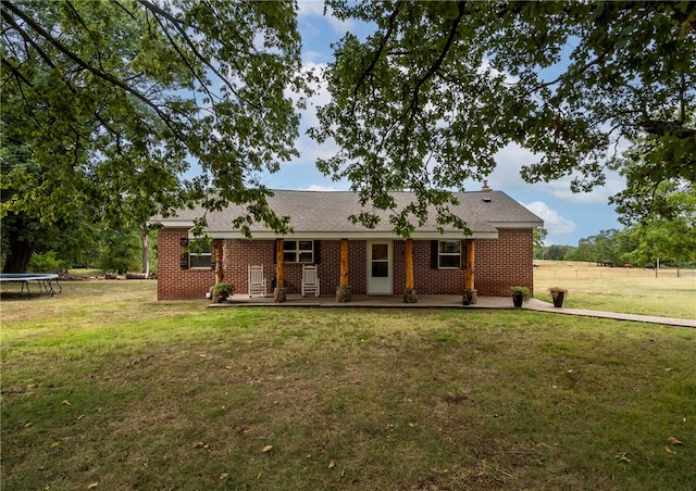 ranch-style home with a front lawn and a trampoline