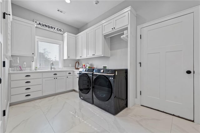 washroom with cabinets, sink, and washing machine and clothes dryer