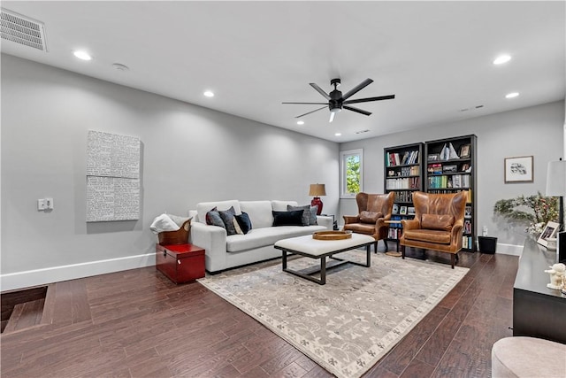 living room featuring ceiling fan and dark hardwood / wood-style floors