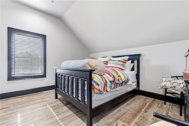 bedroom with hardwood / wood-style flooring and vaulted ceiling