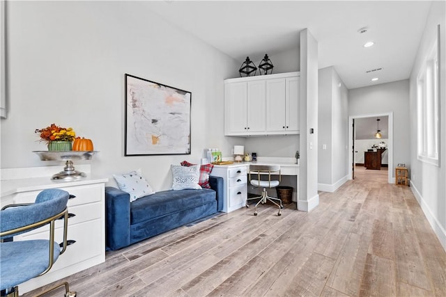 office space featuring light hardwood / wood-style flooring and built in desk