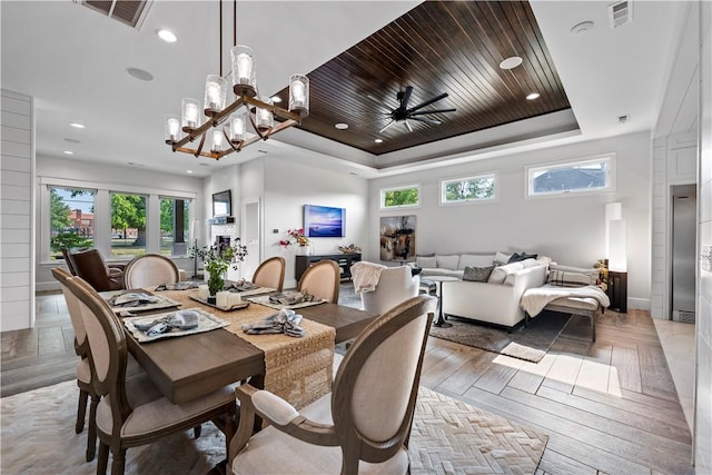 dining room featuring light hardwood / wood-style flooring, wood ceiling, a tray ceiling, and a wealth of natural light