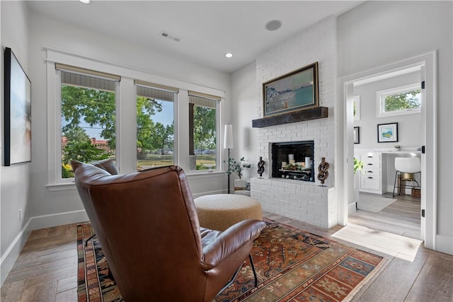 living area featuring wood-type flooring and a fireplace