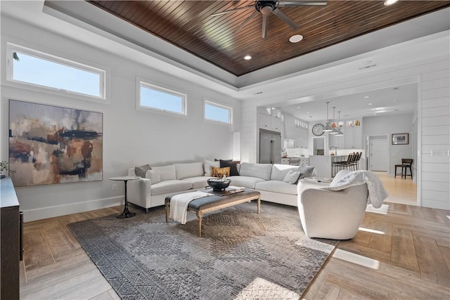 living room with a raised ceiling, ceiling fan, wood ceiling, and light hardwood / wood-style flooring