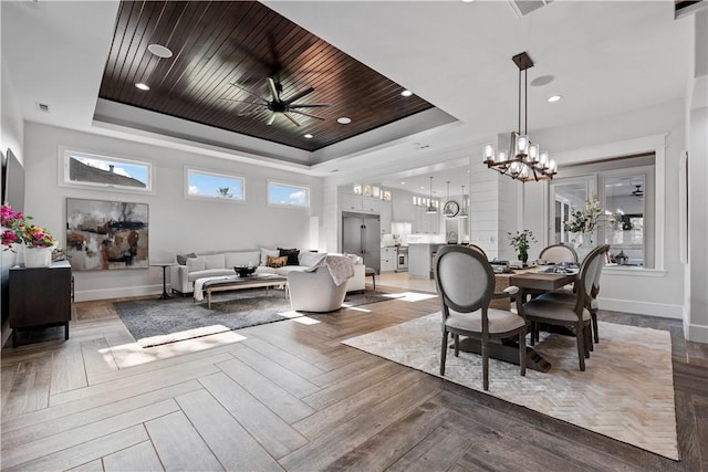 dining room with wood ceiling, ceiling fan with notable chandelier, a raised ceiling, and light parquet flooring