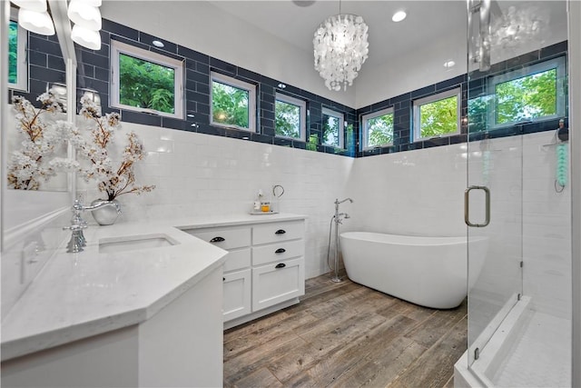 bathroom with vanity, plus walk in shower, hardwood / wood-style floors, and a notable chandelier