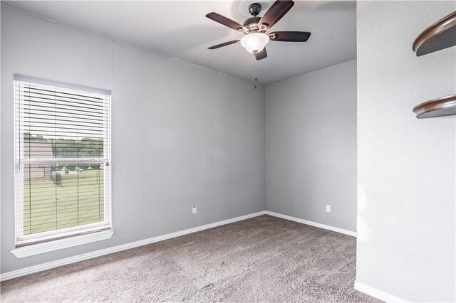 carpeted empty room featuring baseboards and a ceiling fan