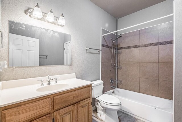 full bathroom featuring toilet, tile patterned flooring, tub / shower combination, vanity, and a textured wall