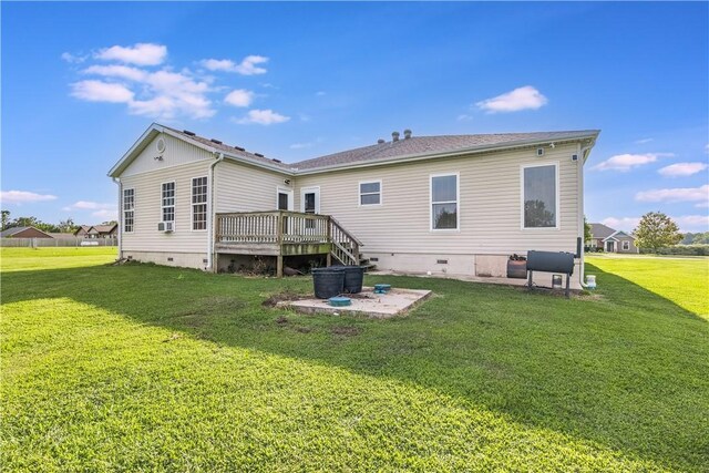 rear view of house with crawl space, a lawn, a wooden deck, and a patio