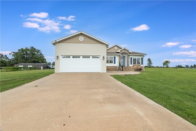 view of front of property with concrete driveway, an attached garage, a front yard, and stone siding