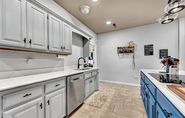 kitchen with visible vents, baseboards, blue cabinetry, a sink, and stainless steel dishwasher