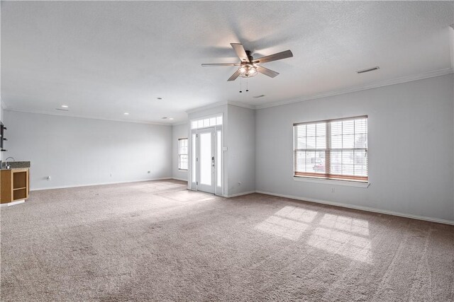 spare room featuring crown molding, a healthy amount of sunlight, visible vents, and baseboards