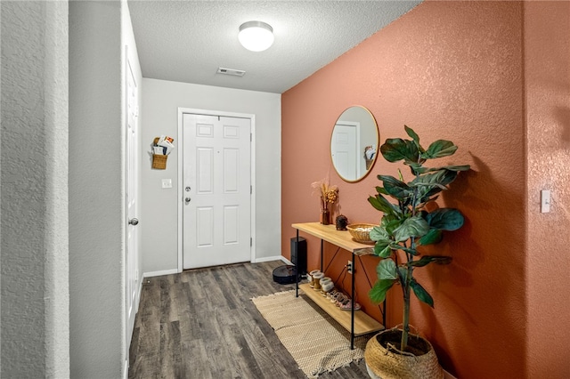 foyer featuring dark hardwood / wood-style flooring and a textured ceiling