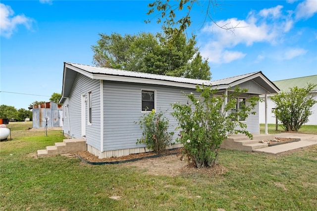 rear view of property featuring a lawn