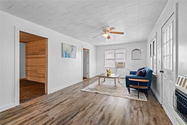 156 Main, Colcord, OK 74338 - living area with ceiling fan, wood finished floors, baseboards, cooling unit, and heating unit