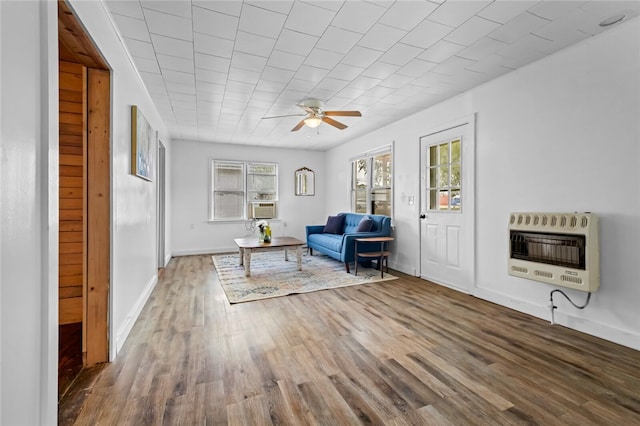 unfurnished room with ceiling fan, wood-type flooring, cooling unit, and heating unit