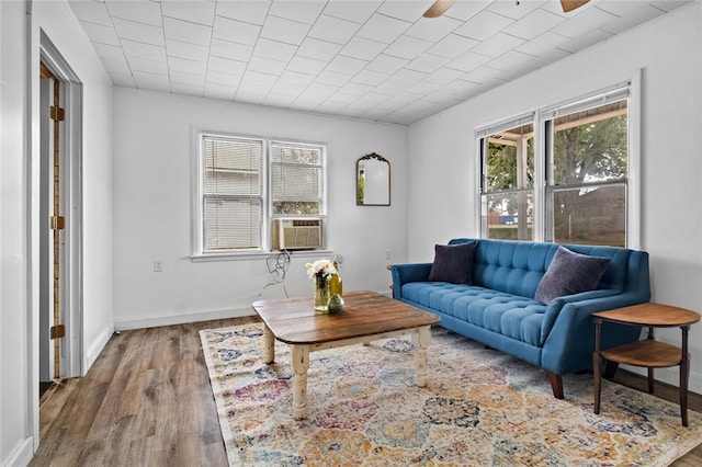 living room with ceiling fan, cooling unit, and hardwood / wood-style flooring