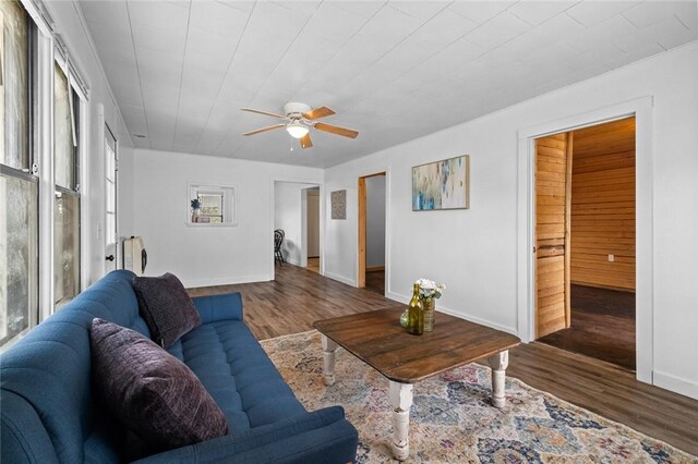 156 Main, Colcord, OK 74338 - living room featuring wood finished floors, a ceiling fan, and baseboards