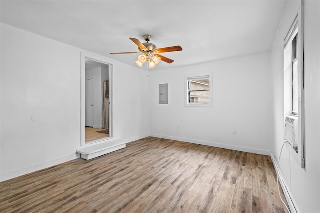 spare room featuring ceiling fan, electric panel, and wood-type flooring