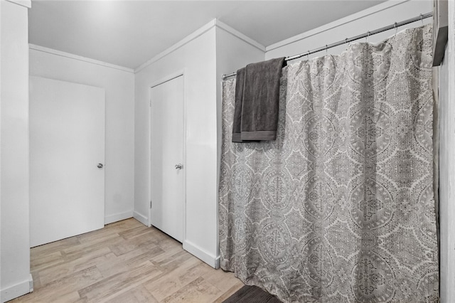 bathroom featuring hardwood / wood-style flooring and crown molding