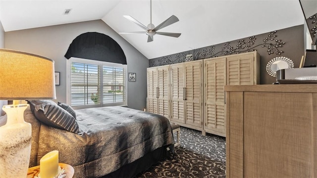 bedroom featuring vaulted ceiling, dark colored carpet, visible vents, and a ceiling fan