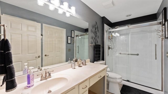 full bath featuring toilet, a stall shower, and vanity