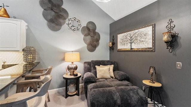 sitting room with lofted ceiling, carpet floors, and baseboards