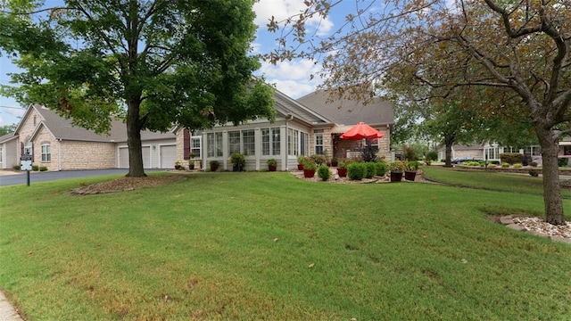 view of front of home with aphalt driveway and a front lawn