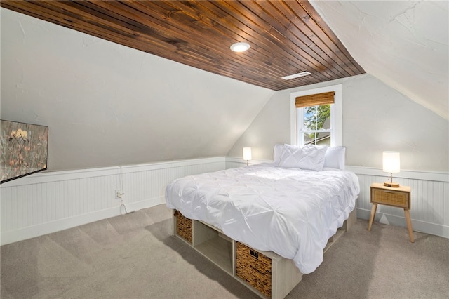 bedroom with vaulted ceiling, carpet floors, wainscoting, and wood ceiling