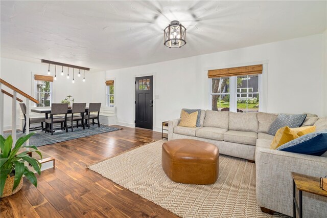 living room with hardwood / wood-style floors, track lighting, a notable chandelier, and plenty of natural light