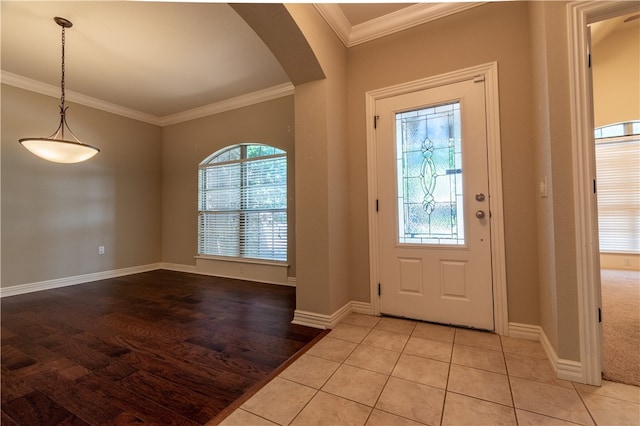 tiled foyer featuring crown molding