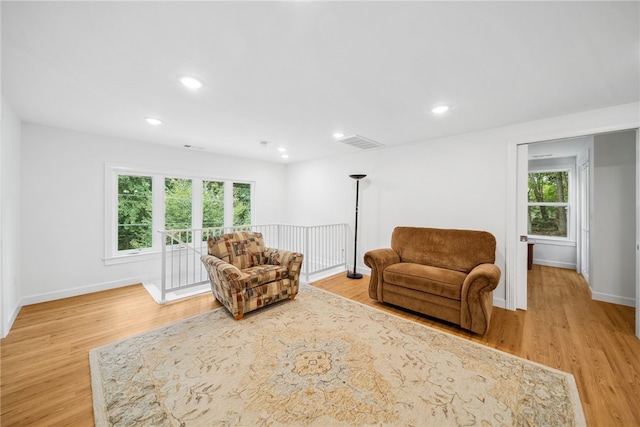 living room with a wealth of natural light and light hardwood / wood-style flooring