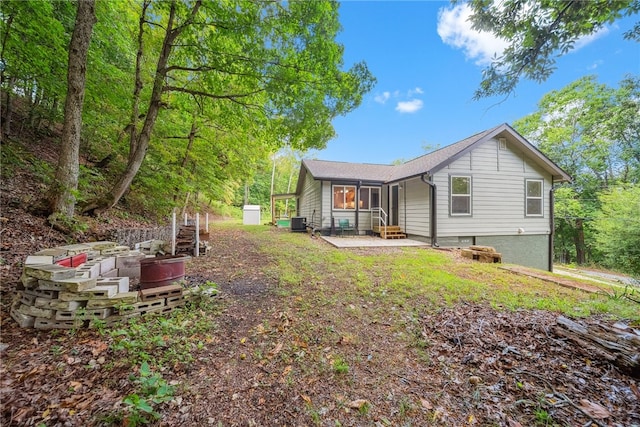 back of property with central AC and a patio