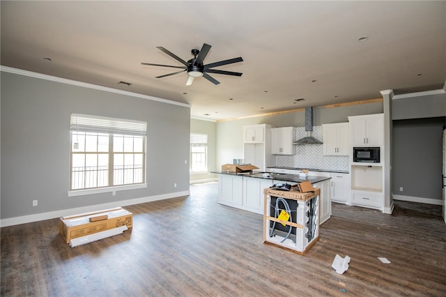 kitchen with a center island, white cabinets, wall chimney range hood, dark hardwood / wood-style floors, and black microwave