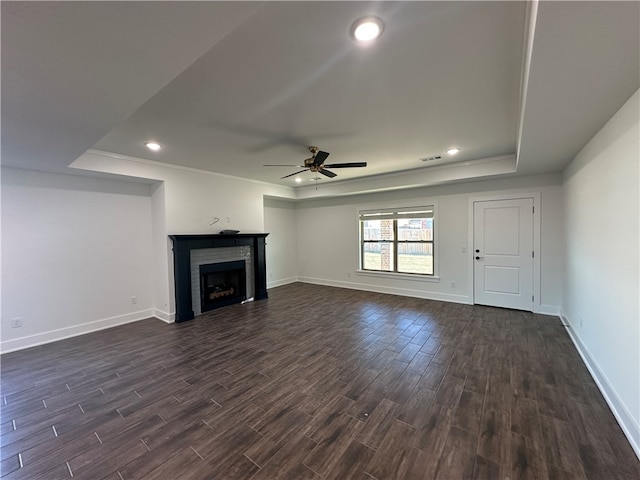 unfurnished living room featuring dark hardwood / wood-style floors, a raised ceiling, and ceiling fan