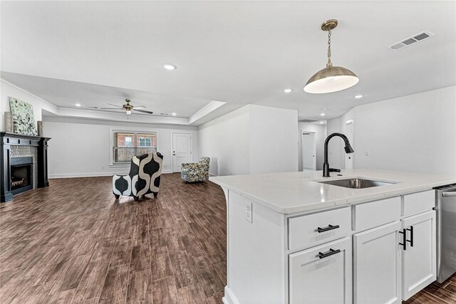 kitchen featuring visible vents, a sink, open floor plan, white cabinetry, and dark wood-style flooring
