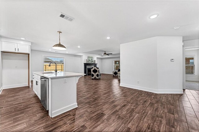 kitchen featuring visible vents, a sink, open floor plan, white cabinetry, and dark wood-style flooring