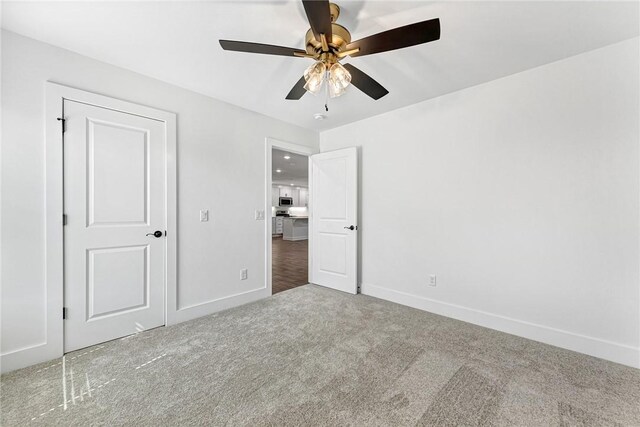 unfurnished bedroom featuring a ceiling fan, baseboards, and carpet floors