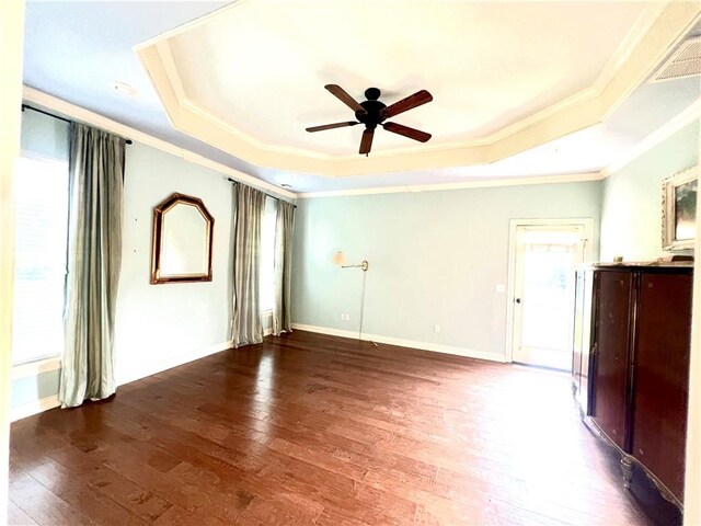 spare room with ceiling fan, wood-type flooring, and a tray ceiling