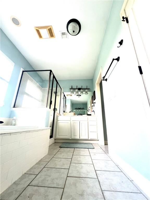 bathroom with separate shower and tub, vanity, and tile patterned floors