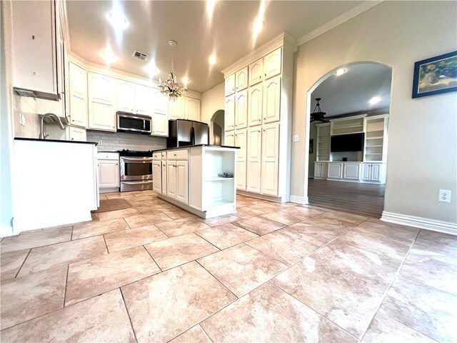 kitchen featuring tasteful backsplash, ornamental molding, white cabinetry, appliances with stainless steel finishes, and light hardwood / wood-style floors