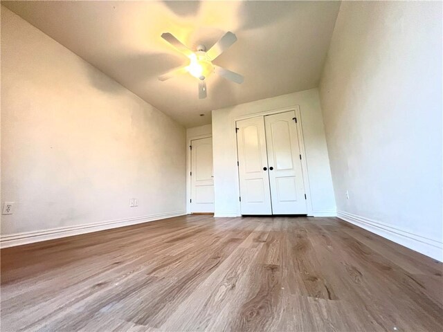 unfurnished bedroom with light hardwood / wood-style floors, ceiling fan, and a closet