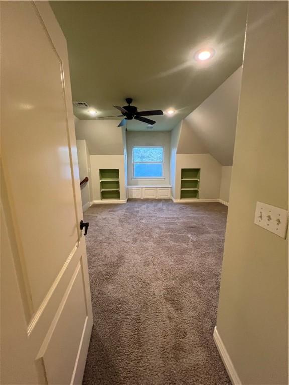 bonus room with ceiling fan, lofted ceiling, carpet floors, and built in shelves